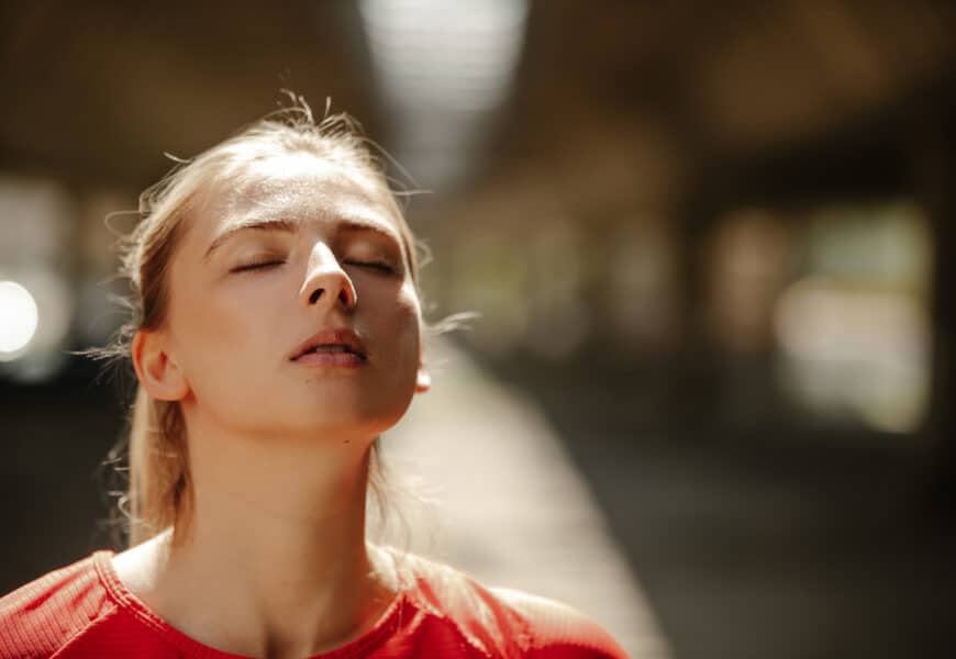 Jeune femme respirant à plein poumon